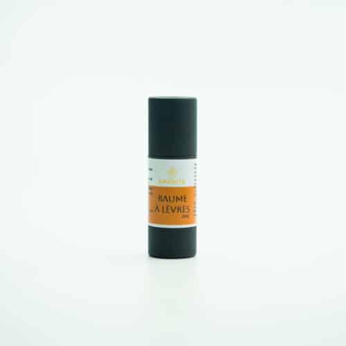 Baume à lèvres AMÉNITÉ en tube noir avec étiquette orange, photographié sur fond blanc minimaliste.